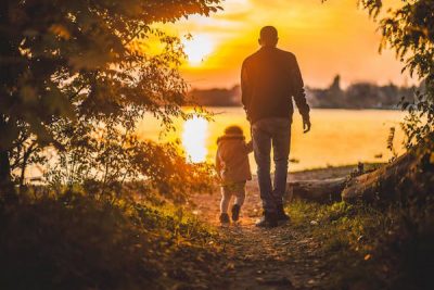 young man walks son out to lake at sunrise